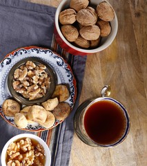 Cup of brewed tea with eastern sweets and spices on wooden table