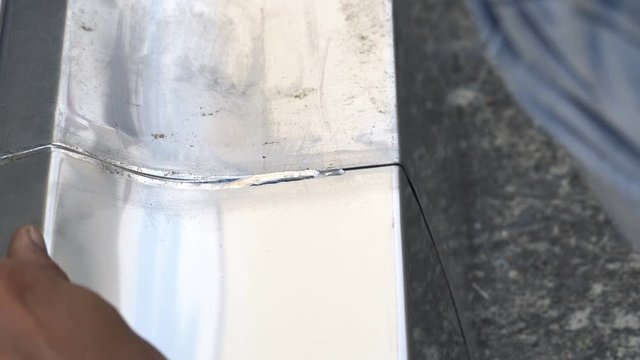 Detail of a roofer welding stainless gutter

