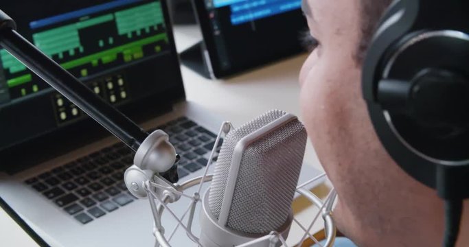 black man creative musician at home studio works by playing,singing and recording guitar with notebook tablet and microphone indoor in modern industrial house. 4k handheld back video shot