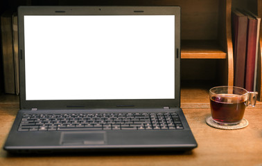 Fototapeta premium Laptop with blank screen and cup of tea on wooden table. Education, business or web social life concept background.