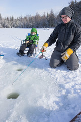 Mixed race family ice fishing