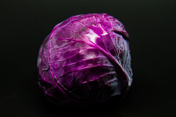 Obraz premium Fresh scotch kale or purple cabbage isolated on black background with selective focus and under exposre