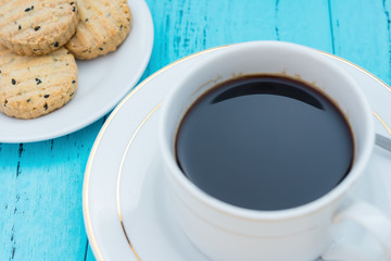 up of coffee and biscuit with seasame on blue background