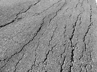 Old worn and cracked asphalt with cracks