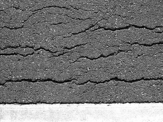Old worn and cracked asphalt with cracks