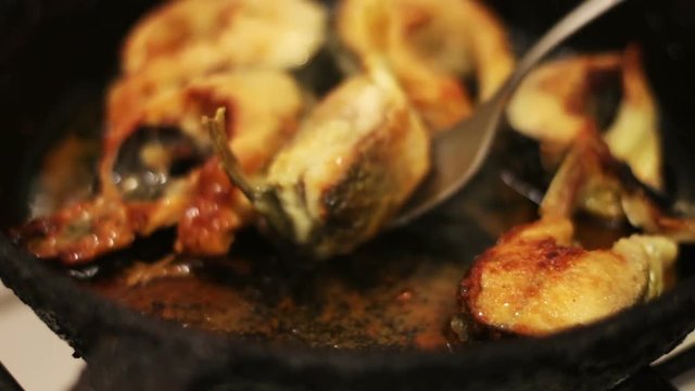 Pieces of freshwater fish frying in a cast-iron skillet