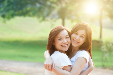 Naklejka premium Asian adult sisters outdoor fun