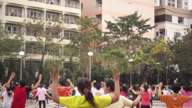 Group of people aerobic dance in city park