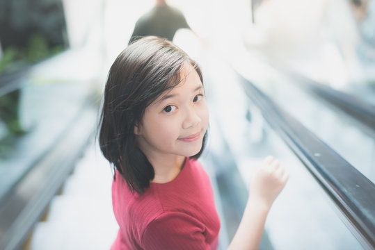 Asian girl  standing on escalator
