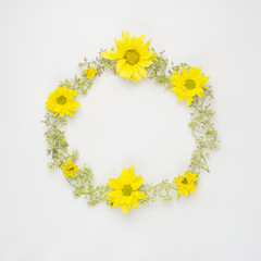 round frame wreath pattern with yellow Chrysanthemums and wild flowers on white background with copy space. flat lay top view.