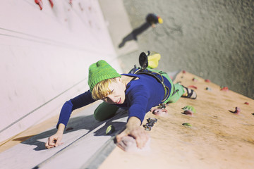 Rock climber reaching for his next hand hold, Joshua Tree National Park.