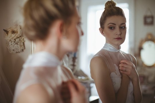 Young bride looking at herself in mirror