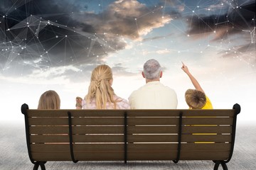 Fototapeta premium Rear view of family sitting on bench against star constellations