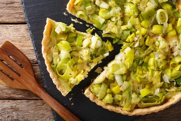  Sliced savory pie with leek and cheese close-up. horizontal top view © FomaA