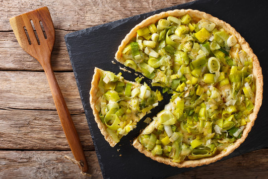 Fototapeta Sliced tart with leek and cheese close-up. Horizontal top view