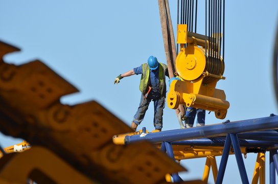 Balance worker guiding a crane (ouvrier en équilibre guidant une grue)
