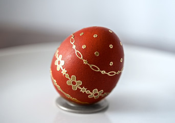Easter red egg with gold decoration isolated on grey background