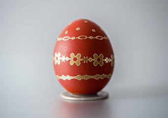 Easter red egg with gold decoration isolated on grey background