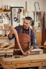 Joiner Makes Cabriole Leg for Vintage Table/Carpenter works with a planer in a workshop for the production of vintage furniture. He makes cabriole leg for a table in the style of Louis XV