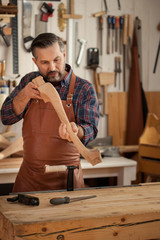Exquisite Lines of the Cabriole's Legs/Carpenter works with a planer in a workshop for the...
