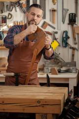 A Wooden Horse is a Toy for All Time/Carpenter works with a planer in a workshop for the production of vintage furniture. He makes wooden horse for his grandson