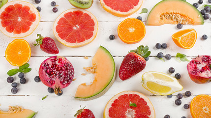 Fresh mixed fruits on  white wooden background. Healthy food concept.