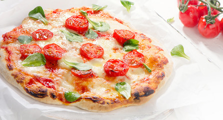 Italian Pizza on a white wooden board.