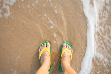 foot and sandal on the sand beach.