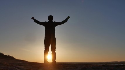 Fototapeta premium freedom. Man stands on a cliff sunset silhouette hand lifestyle in the sides