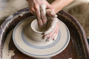 Hands working on pottery wheel