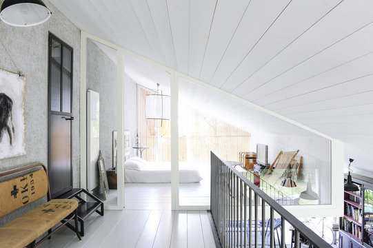 Corridor and access to a white bedroom with wooden materials 