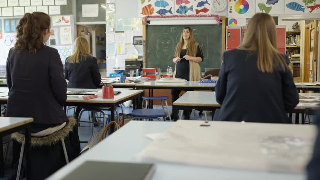 Teacher talking to her teenage students in school art class