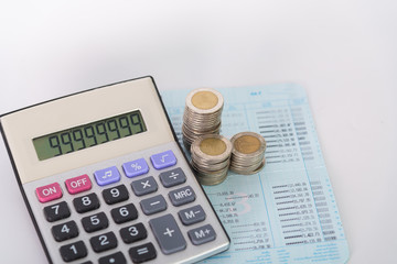 Increasing columns of coins, piles of coins arranged as a graph and calculator on white background