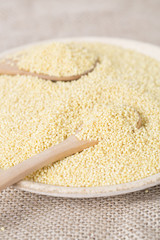 Yellow millet seeds in a wooden bowl on the table