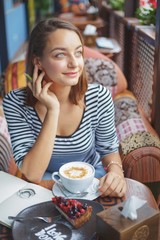 Young woman sitting indoor in urban cafe