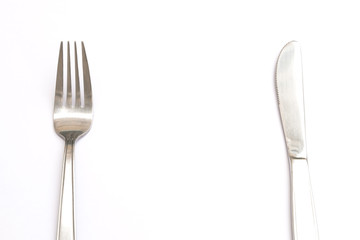 Fork and knife on white table with space