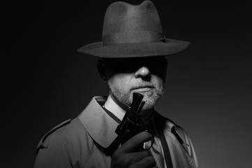 Detective holding a gun in the dark