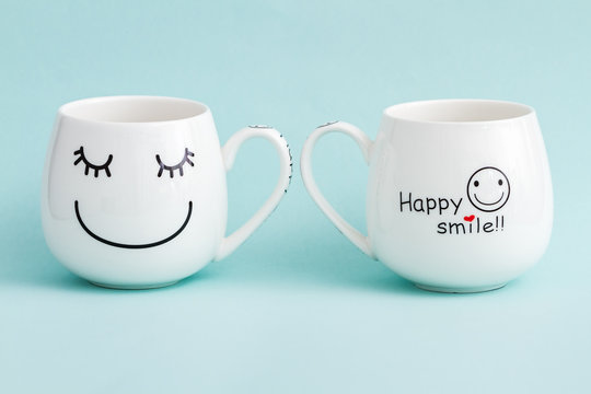 Smiling White Coffee Mugs On Green Background