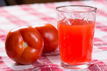 Tomato juice on the table with fresh raw tomatos