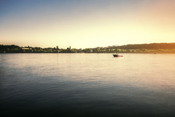 Fototapeta na wymiar See mit Sonnenuntergang und Boot