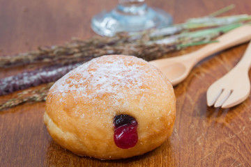 fresh donuts with jam isolated on wooden table
