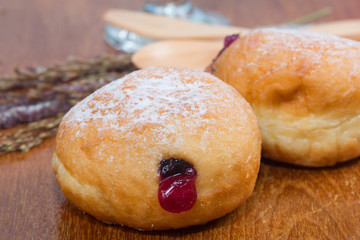 fresh donuts with jam isolated on wooden table
