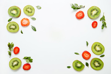 Fruit background of kiwi, strawberries and greens. Flat lay, top view