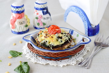 Grilled portobello mushroom with spinach, pinenuts,onions and cheese in a ceramic pot. Helathy eating concept. Mediterranean lifestyle.