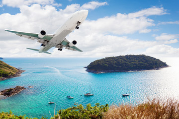 Fototapeta na wymiar Airplane flying with tropical island,popular travel destinations in phuket thailand.