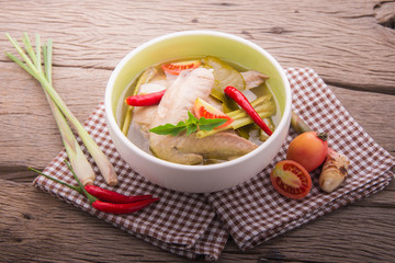 chicken wing tom yum in bowl on wood background.