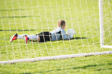 Kids soccer football - goal keeper on the  match on soccer field
