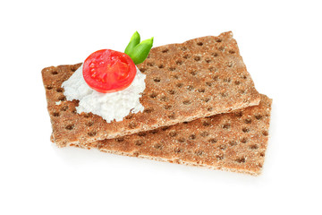 Crispbread with soft cottage cheese, red tomato slices and green leafes. Isolated on white background