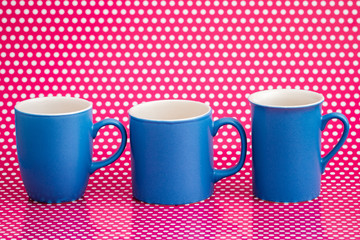 Colorful Coffee Mugs on Pink Background with White Dots