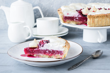 A piece of berry pie with a meringue served on a white dish